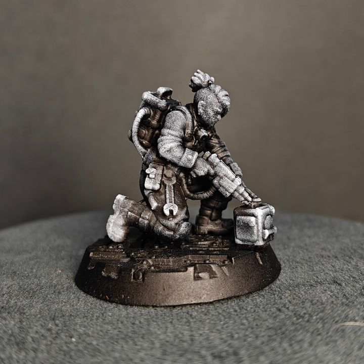 Rear and side view of crouching tech specialist miniature with tools and backpack detail
