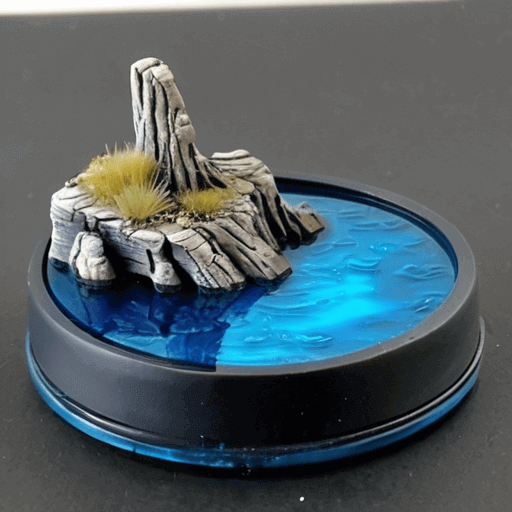 Miniature base featuring a rocky outcrop and custom blue water effects with tufts of grass.