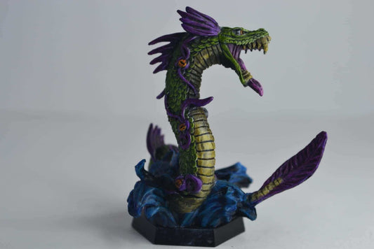 Vibrant green and purple dragon miniature on a blue base, showcasing detailed commission painting.