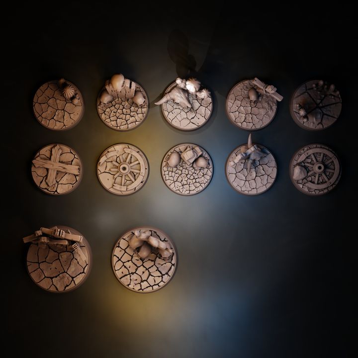 Top-down view of all 12 wasteland bases showing cracked earth texture, wagon wheels, bone and wooden cross detail