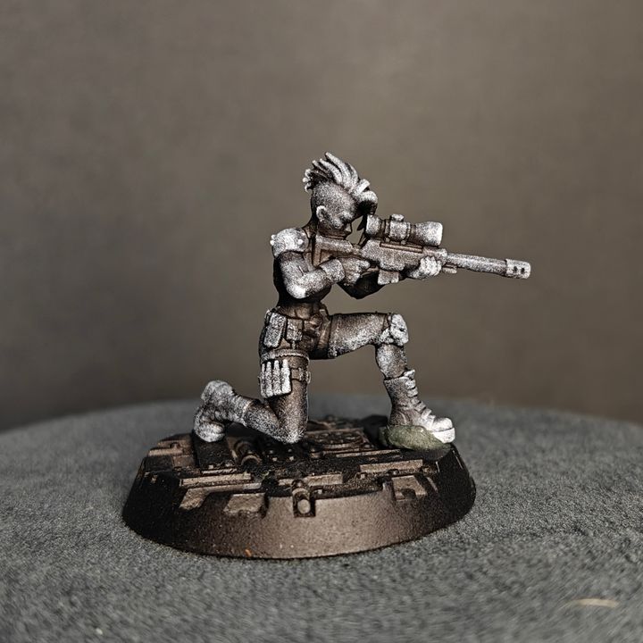 Front-facing kneeling sniper figure in firing stance, spiked hair, scoped rifle raised to eye level